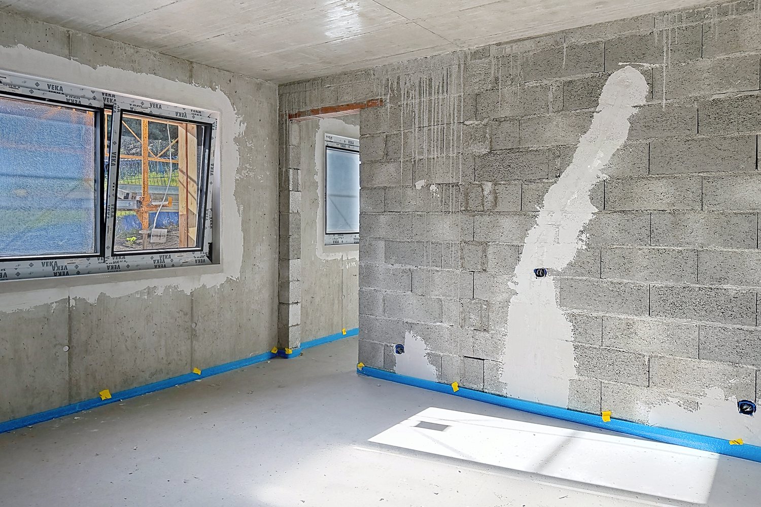 Chambre en gros œuvre, fenêtres posées, receveur de douche entreposé.
