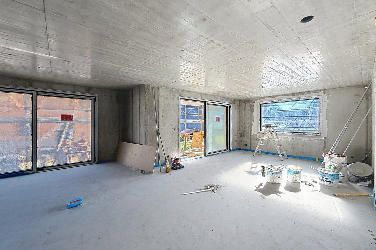 Volume intérieur en gros œuvre, baies posées, chape réalisée.
